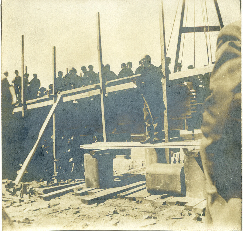 A crowd gathered on scaffolding as the cornerstone of the library is laid